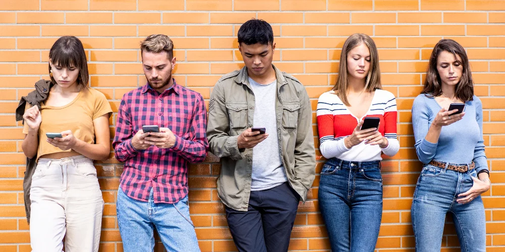 Fünf Personen schauen auf ihre Smartphones